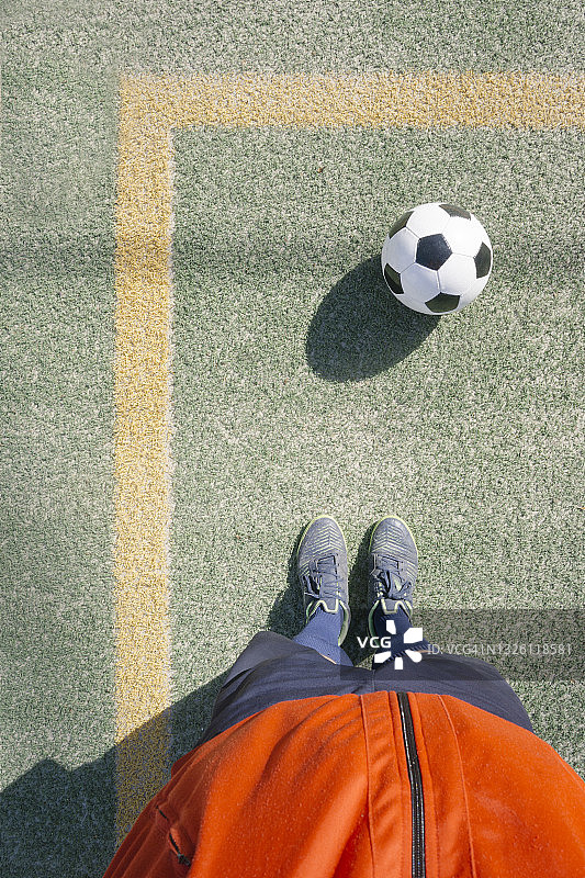 站在足球场足球前的男人图片素材