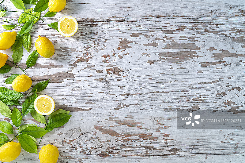 白色木纹背景上的柠檬和柠檬树叶图片素材