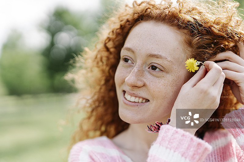 美丽的红发微笑女人戴着花图片素材