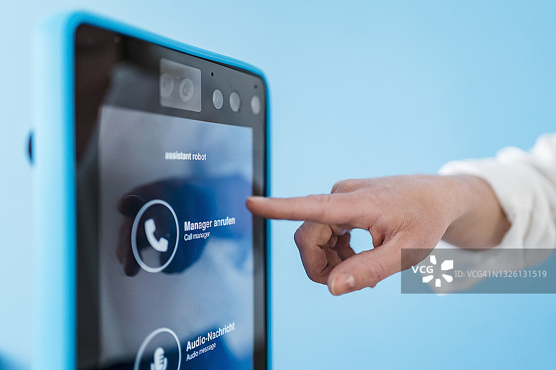 在办公室触摸机器人助手的女商人图片素材