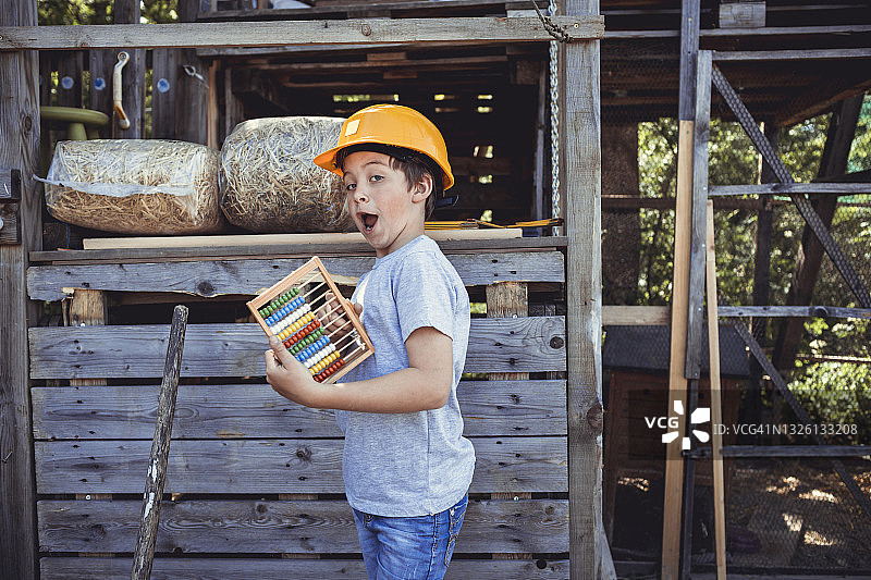 在后院拿着算盘的可爱男孩图片素材
