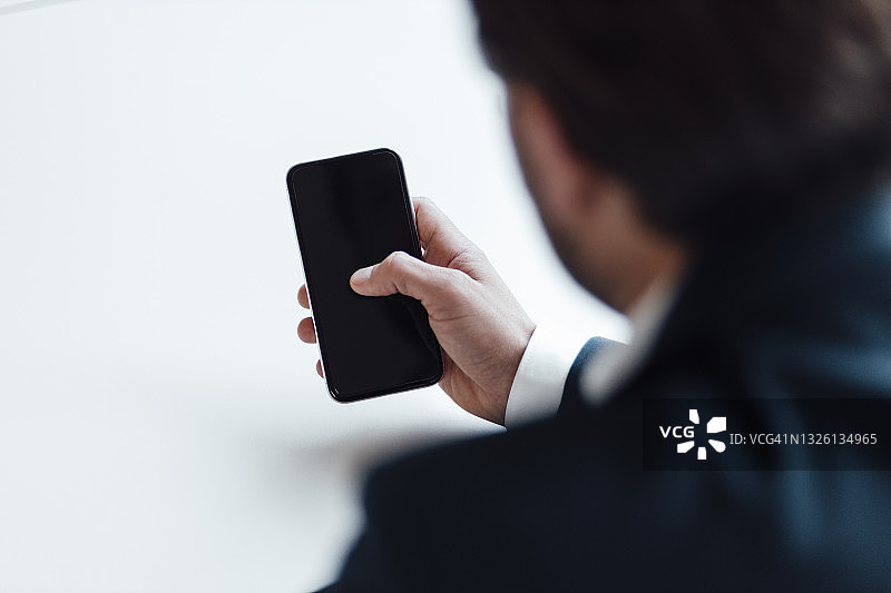 在办公室使用智能手机的男商人图片素材