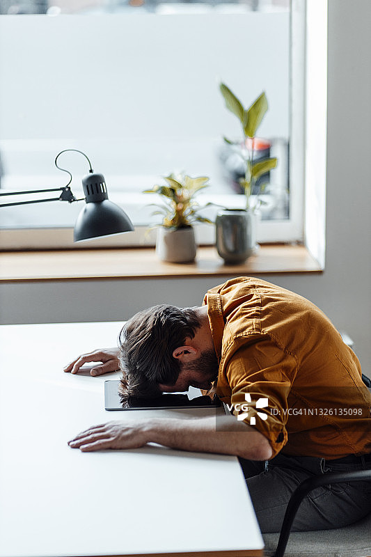 坐在办公室，靠在桌子上的商人图片素材