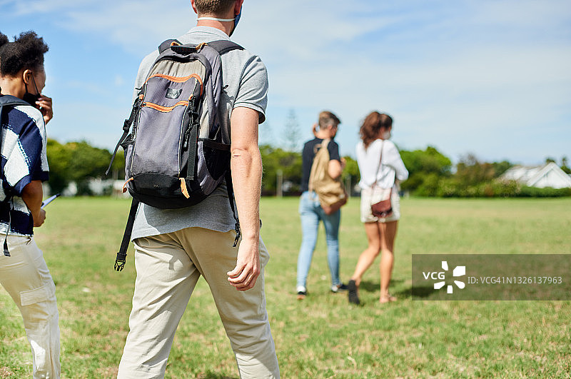 戴着口罩走在校园里的大学生图片素材