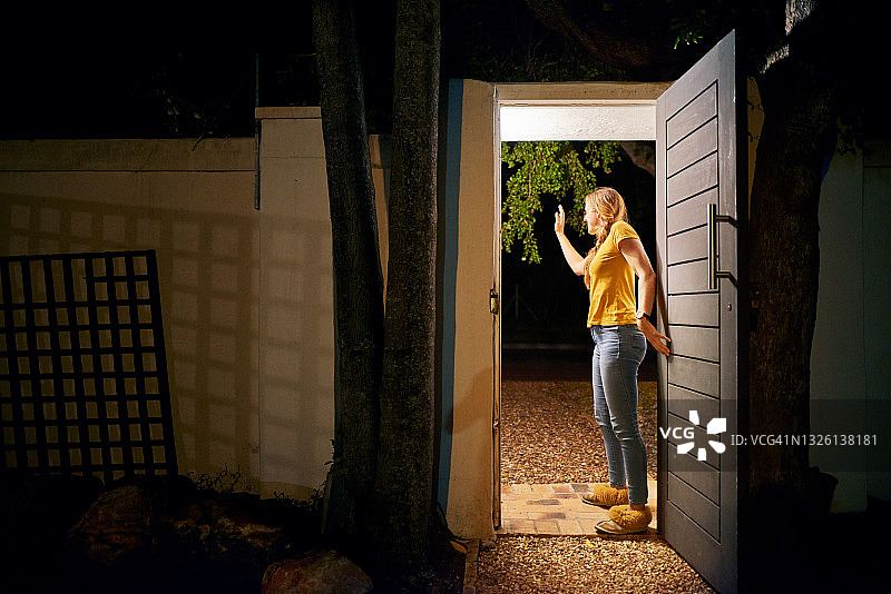 女子在前院门口挥手告别图片素材