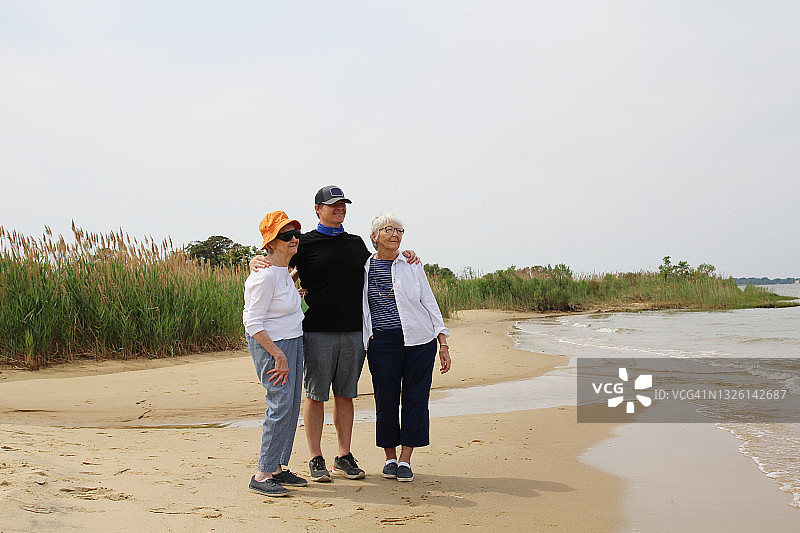 老年妇女和成年男子在切萨皮克湾海滩游玩图片素材