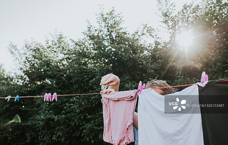 男人在晾衣绳上晾晒湿衣服图片素材