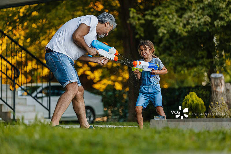 男孩和他的爷爷玩水枪图片素材