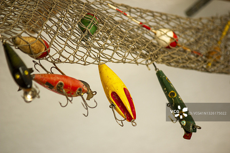 挂在渔网上的复古钓鱼诱饵，带有红色和白色浮标图片素材