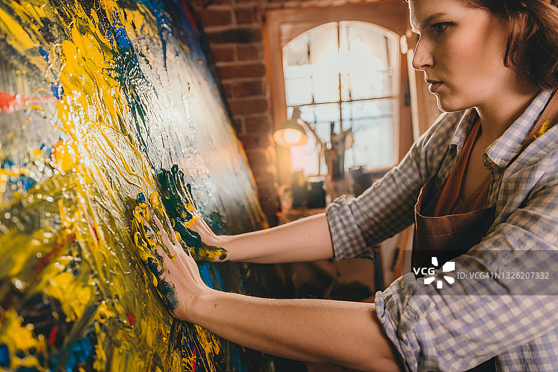 女艺术家在画布上用手绘画图片素材