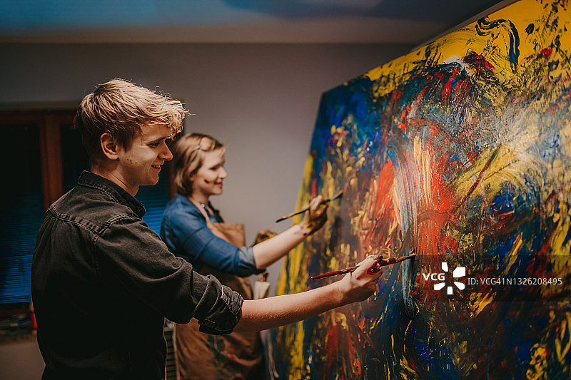 年轻夫妇用手在画布上绘画图片素材