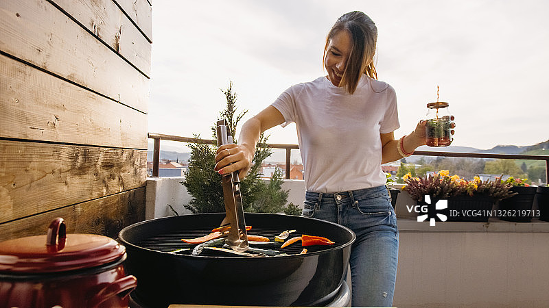 用钳子烤食物的年轻女孩图片素材