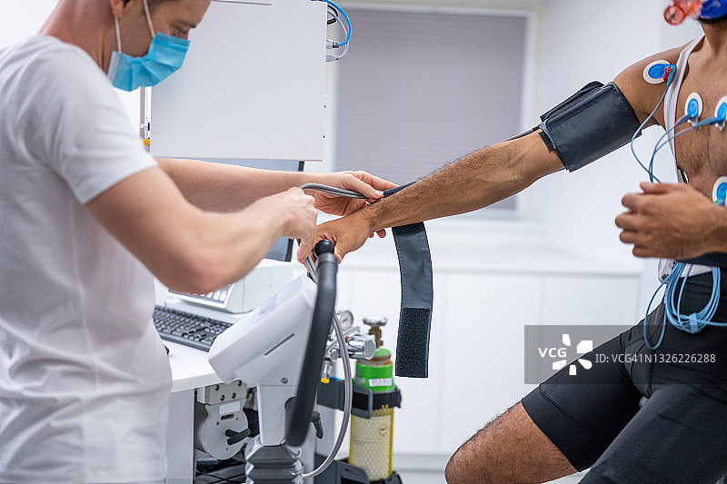 男医生为男运动员量血压图片素材