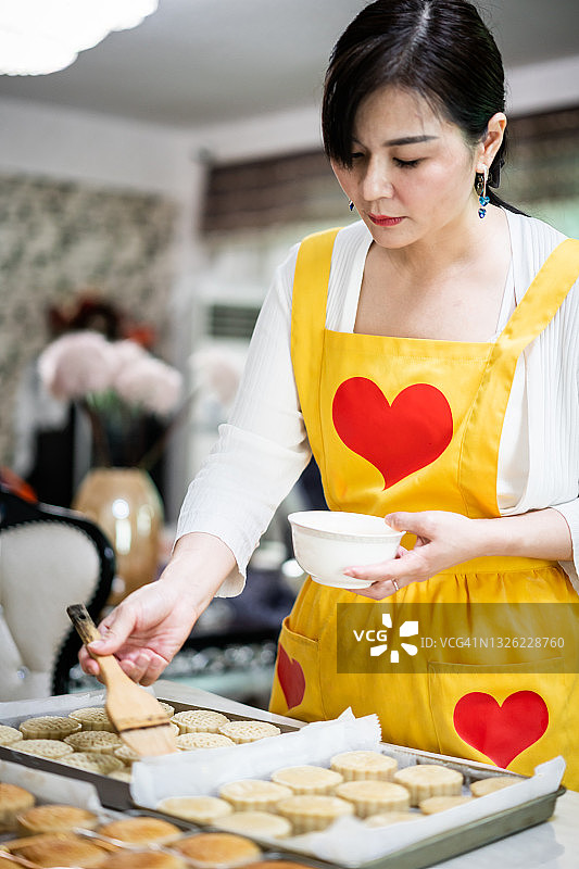 年轻的亚洲女子正在烘焙图片素材