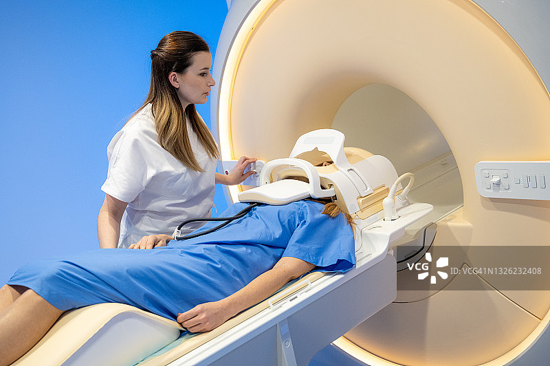 女医生将患者送入MRI扫描仪图片素材