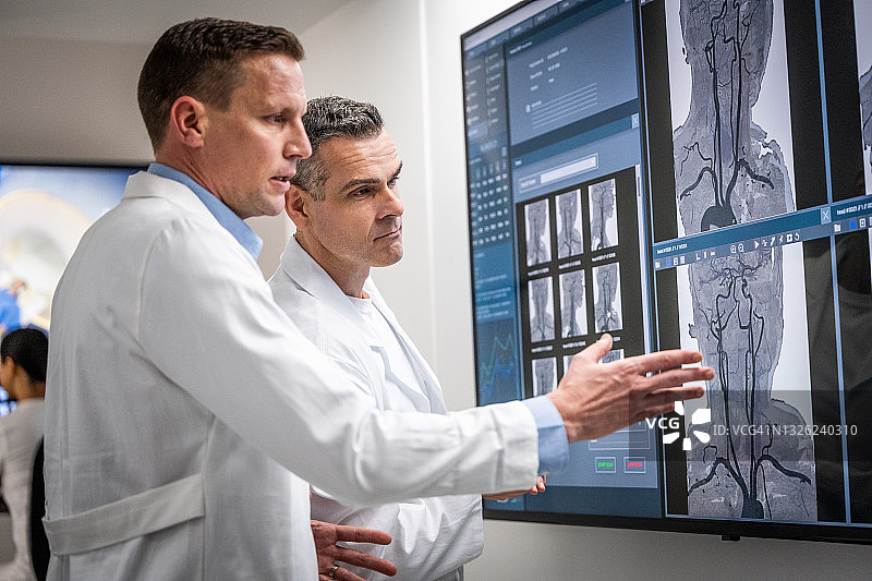 男放射科医生在看片灯上查看MRI图像图片素材