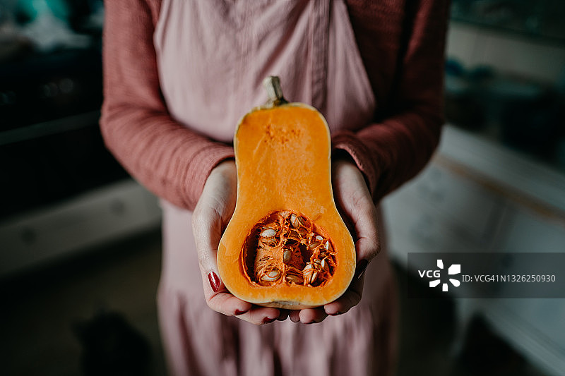女人拿着半个新鲜的冬南瓜图片素材