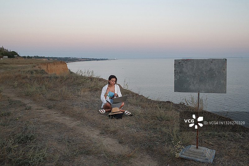 女孩在空旷的海边远程工作图片素材