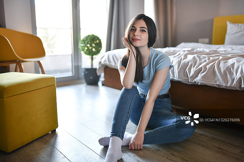 在卧室地板上放松的美丽女性图片素材