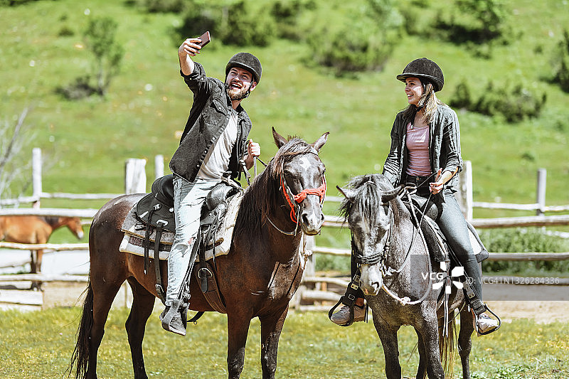 男人在山地马场与骑马女学员自拍图片素材