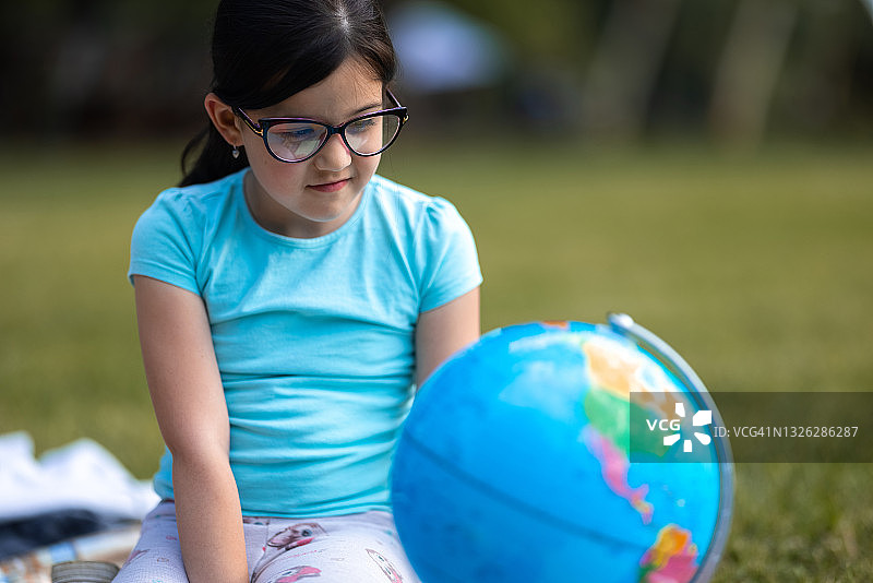 探索地球仪的可爱女学生图片素材