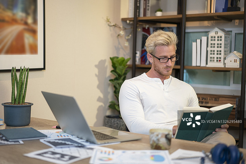 男人在桌子旁看书图片素材