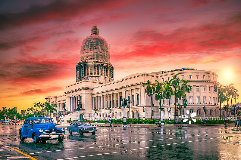 日落时分在国会大厦前行驶的蓝色老爷车图片素材