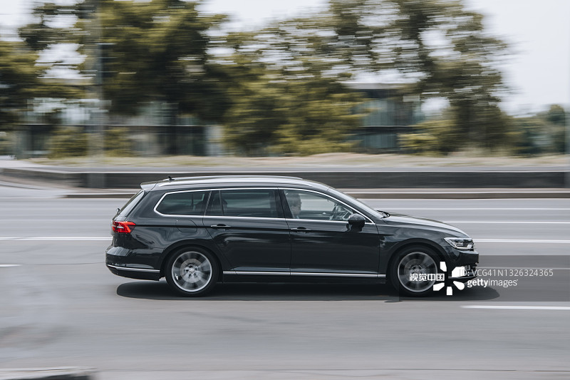 在街上行驶的黑色大众帕萨特汽车图片素材