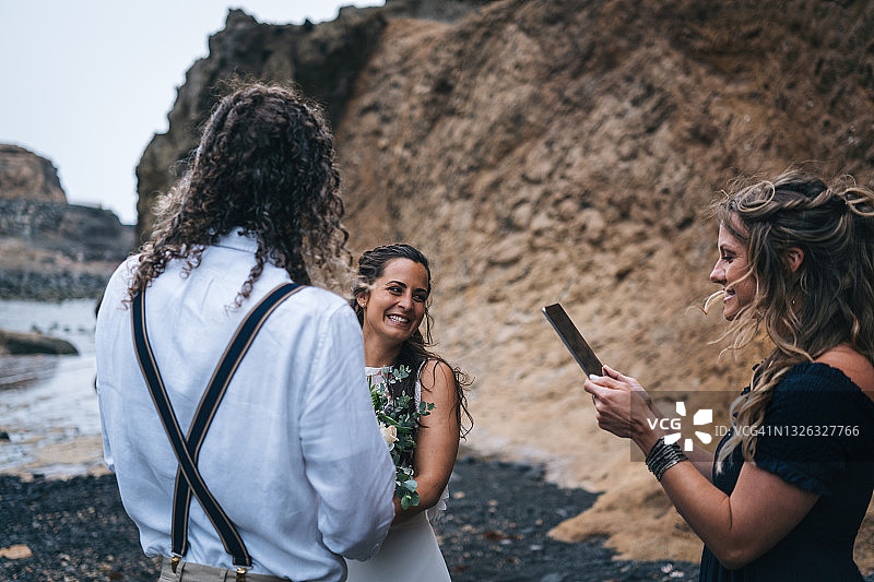 年轻夫妇在岩石海滩上举行婚礼图片素材