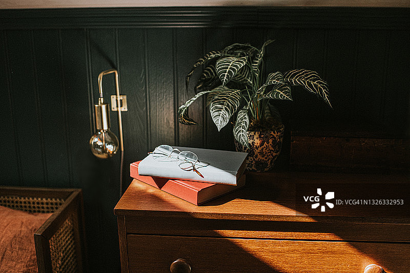 床头柜上堆叠的两本书上的老花镜图片素材