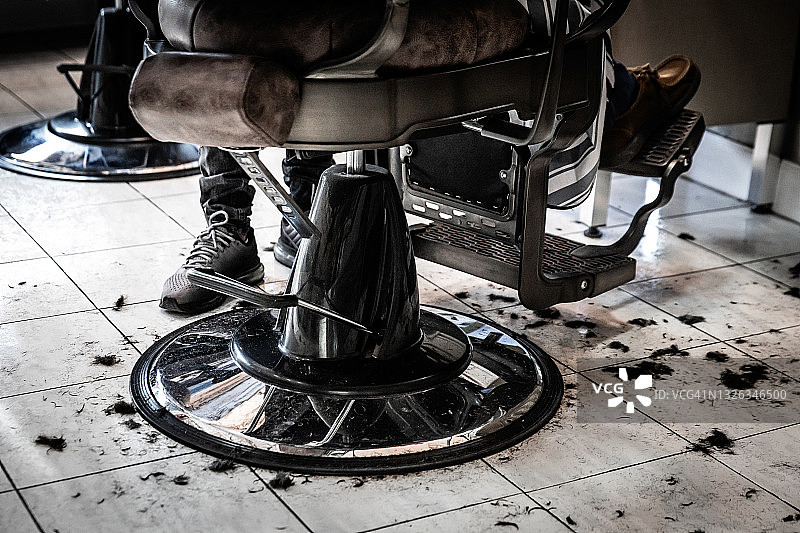 理发店椅子底座的细节，周围是剪掉的头发图片素材