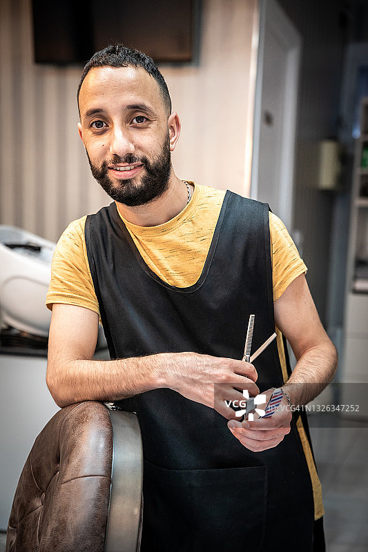 理发师在沙龙靠在椅子上的正面图图片素材