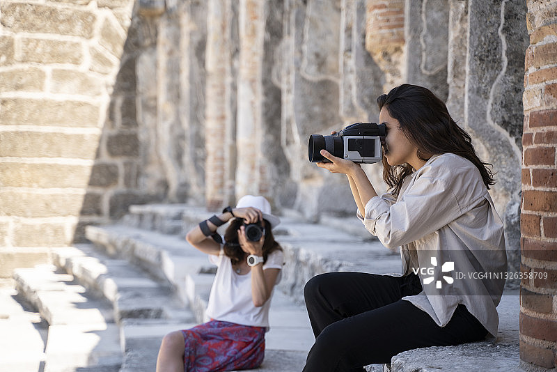 在土耳其安塔利亚阿斯潘多斯圆形剧场拍照的男女游客摄影师图片素材