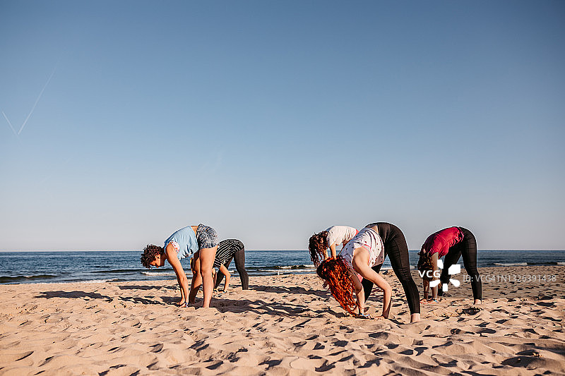 在海滩上进行集体瑜伽图片素材