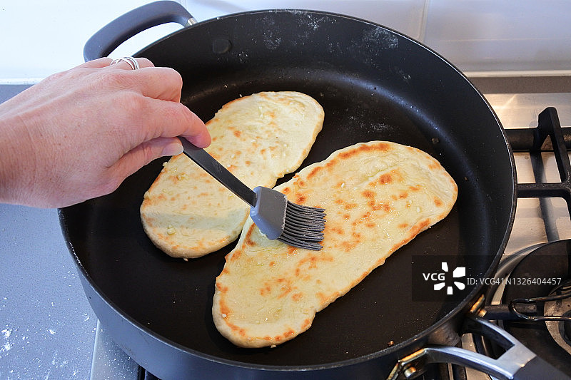 印度妇女烘烤自制馕图片素材