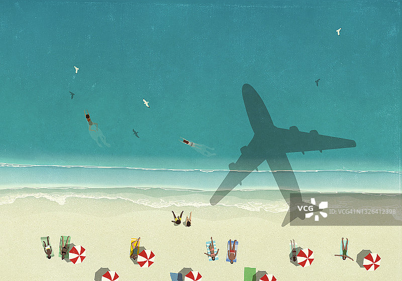 航拍：飞机飞过阳光明媚的沙滩，在游客身上投下阴影图片素材