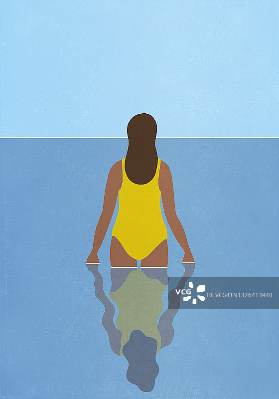 身穿黄色泳衣的女人在蓝色海洋中涉水图片素材