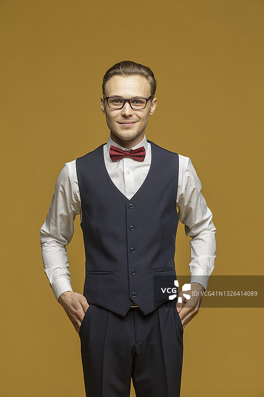 影棚人像：英俊的年轻男人穿着西装和领结图片素材