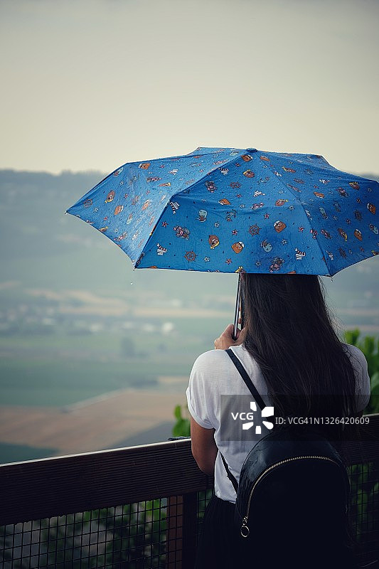雨中带伞看风景的女孩图片素材