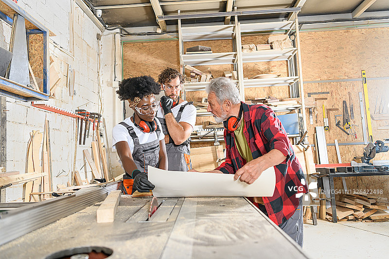 非裔美国女木匠和她的男同事检查工作蓝图图片素材