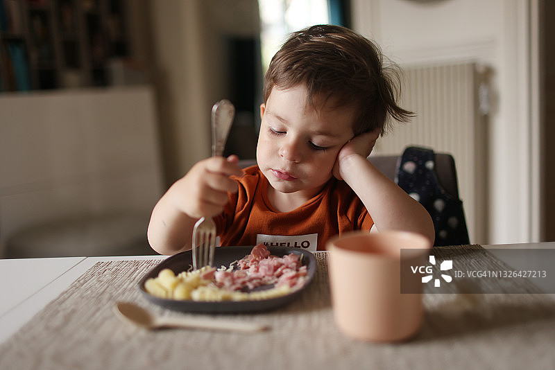 一个3岁的小男孩在家吃午饭图片素材