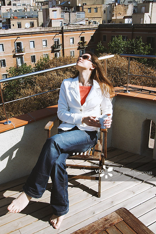 年轻女子在屋顶咖啡馆欣赏城市美景图片素材