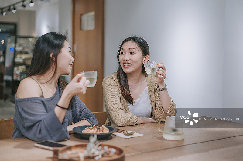 周末在咖啡馆里喝茶的两名中国女性朋友图片素材