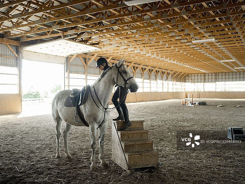 年轻女驯马师准备她的马图片素材