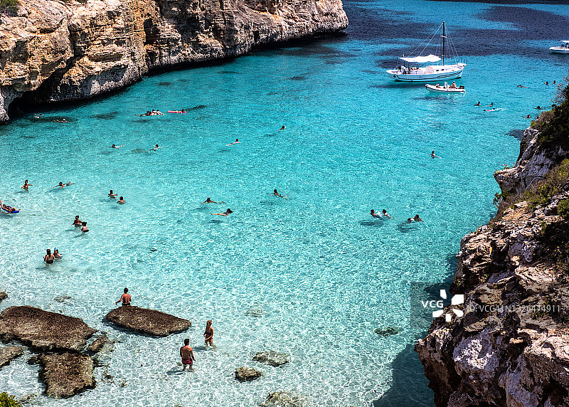 人们在马略卡岛摩洛海湾岩石间清澈的小海湾中沐浴图片素材