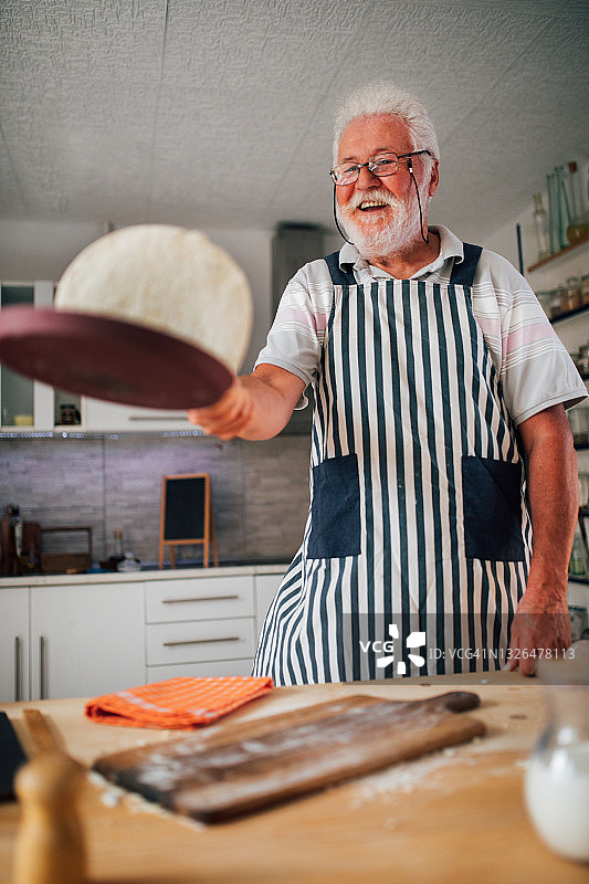 年长的男人在厨房做薄煎饼图片素材