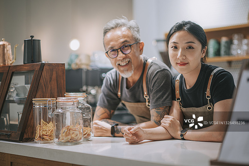 华人咖啡店老板和她的女儿在咖啡店柜台看着镜头微笑图片素材