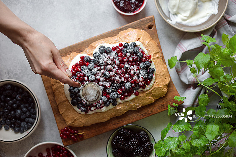 准备制作浆果巴甫洛娃蛋糕，配有蓝莓、黑莓和红醋栗图片素材