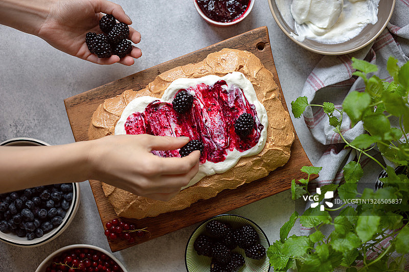 准备制作浆果巴甫洛娃蛋糕，配有蓝莓、黑莓和红醋栗图片素材