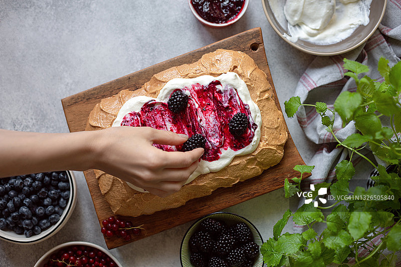 准备制作浆果巴甫洛娃蛋糕，配有蓝莓、黑莓和红醋栗图片素材